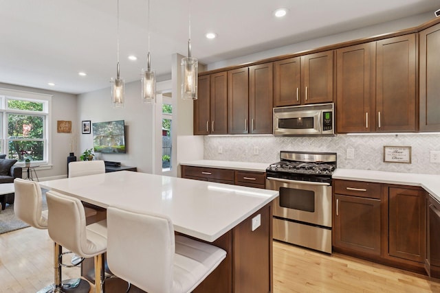 4312 France Ave S, Edina, MN 55410 - kitchen featuring stainless steel appliances, light wood-style flooring, light countertops, decorative backsplash, and recessed lighting