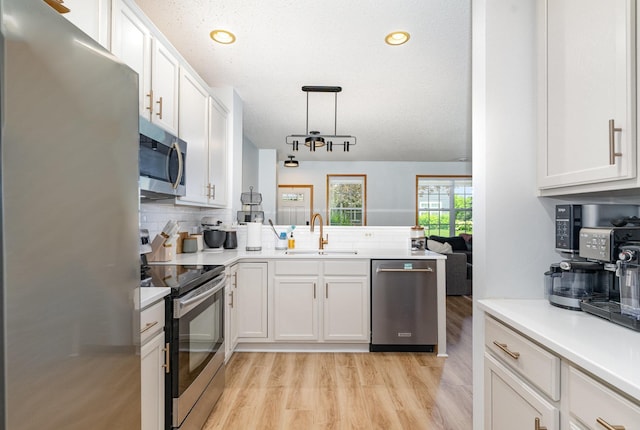 14399 Banyan Ln, Rosemount, MN 55068 - kitchen featuring stainless steel appliances, backsplash, light wood-type flooring, light countertops, and white cabinets