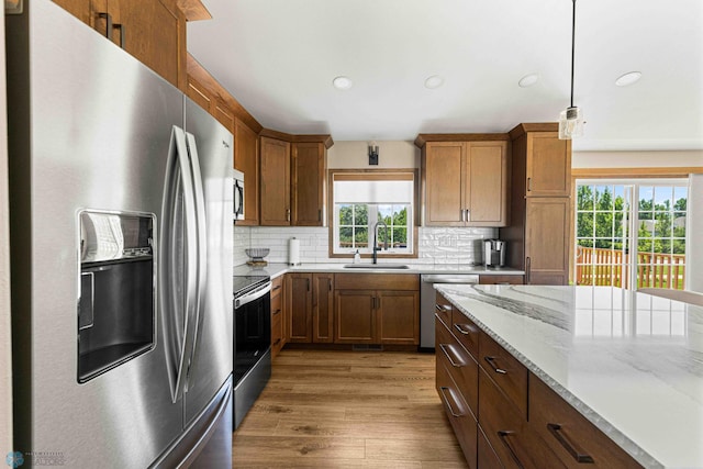 4515 Westport Pkwy, Fargo, ND 58078 - kitchen with appliances with stainless steel finishes, tasteful backsplash, wood finished floors, decorative light fixtures, and recessed lighting