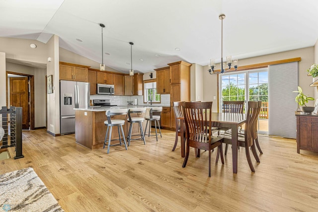 4515 Westport Pkwy, Fargo, ND 58078 - dining room with lofted ceiling, light wood-style flooring, and a chandelier