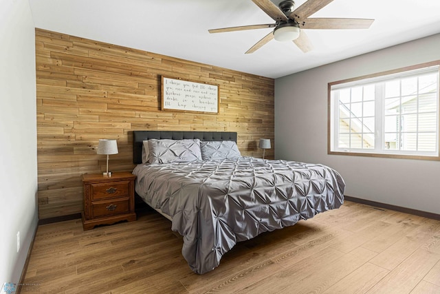 4515 Westport Pkwy, Fargo, ND 58078 - bedroom with wooden walls, wood finished floors, an accent wall, and ceiling fan