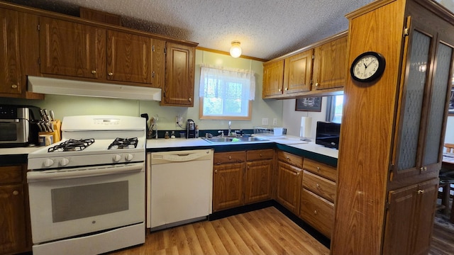 3665 Fox Ln, Pequot Lakes, MN 56472 - kitchen featuring white appliances, under cabinet range hood, light wood-style flooring, a textured ceiling, and brown cabinetry
