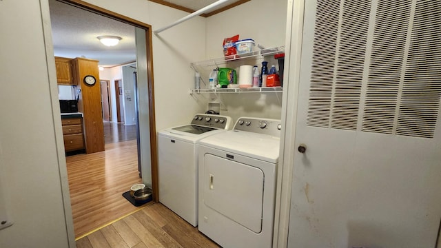 3665 Fox Ln, Pequot Lakes, MN 56472 - laundry area with a heating unit, washing machine and clothes dryer, and light wood-style floors
