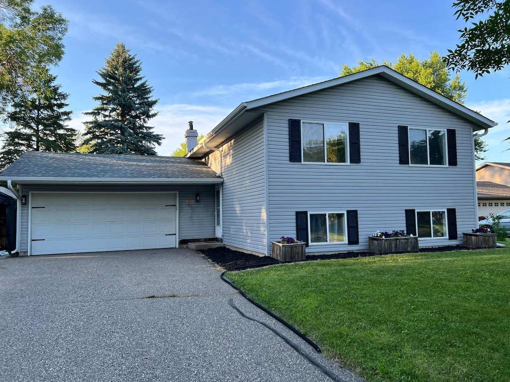 401 Sigrid Dr, Buffalo, MN 55313 - tri-level home with a garage, a front lawn, driveway, and a chimney