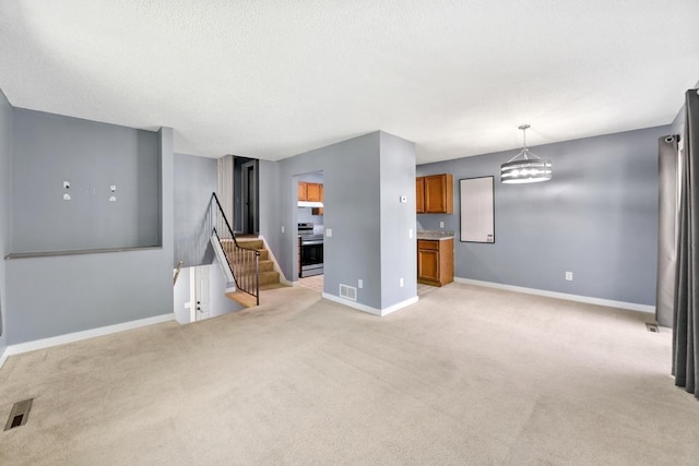 3615 156th St W, Rosemount, MN 55068 - unfurnished living room with light carpet, a chandelier, and a textured ceiling