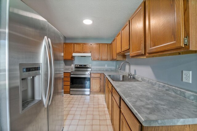 3615 156th St W, Rosemount, MN 55068 - kitchen featuring appliances with stainless steel finishes, under cabinet range hood, brown cabinetry, light tile patterned flooring, and light countertops