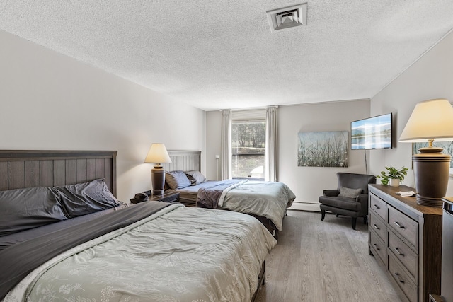 6615 Lake Shore Dr S Unit 314, Richfield, MN 55423 - bedroom featuring light wood-type flooring, a textured ceiling, and baseboard heating
