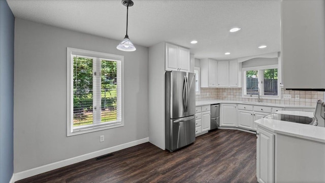 12720 Ibis St NW, Coon Rapids, MN 55448 - kitchen with stainless steel appliances, decorative backsplash, dark wood finished floors, light countertops, and white cabinets