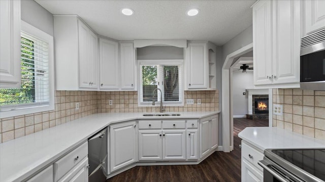 12720 Ibis St NW, Coon Rapids, MN 55448 - kitchen featuring appliances with stainless steel finishes, dark wood-style flooring, a ceiling fan, white cabinets, and light countertops