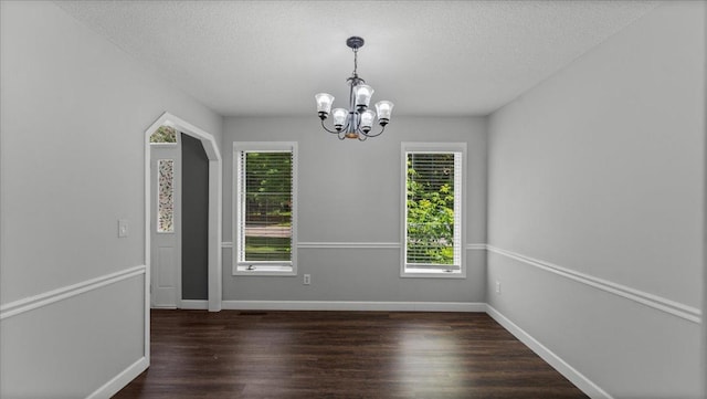 12720 Ibis St NW, Coon Rapids, MN 55448 - unfurnished dining area featuring a chandelier, dark wood-style flooring, and a textured ceiling