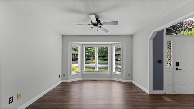 12720 Ibis St NW, Coon Rapids, MN 55448 - entrance foyer with dark wood-style floors, arched walkways, a textured ceiling, and ceiling fan
