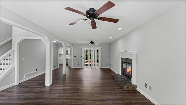 12720 Ibis St NW, Coon Rapids, MN 55448 - unfurnished living room with a glass covered fireplace, stairway, wood finished floors, recessed lighting, and arched walkways