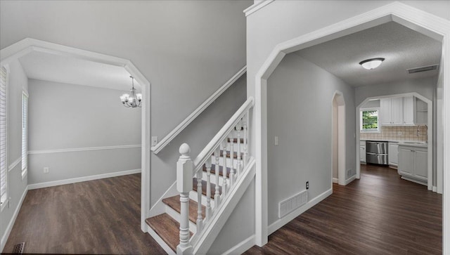 12720 Ibis St NW, Coon Rapids, MN 55448 - staircase with wood finished floors, arched walkways, and a chandelier