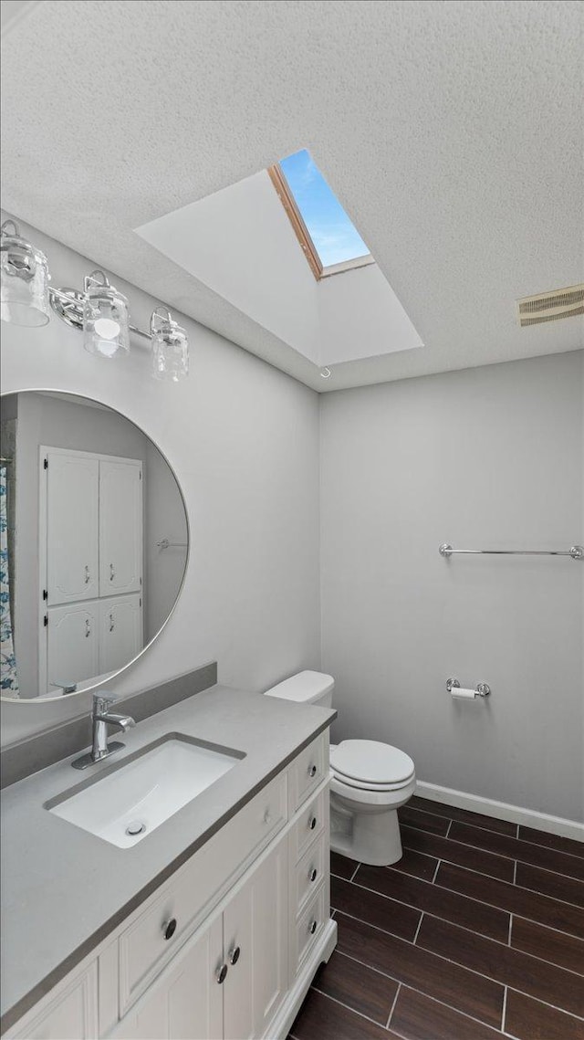 12720 Ibis St NW, Coon Rapids, MN 55448 - bathroom with a skylight, vanity, wood tiled floors, and a textured ceiling