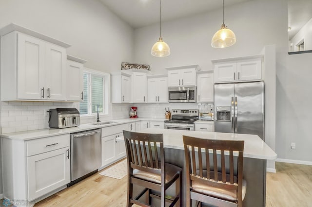 401 7th St E, Horace, ND 58047 - kitchen with appliances with stainless steel finishes, high vaulted ceiling, decorative backsplash, light wood-style flooring, and white cabinetry