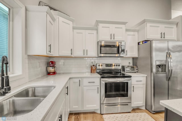 401 7th St E, Horace, ND 58047 - kitchen with appliances with stainless steel finishes, white cabinets, and light wood finished floors