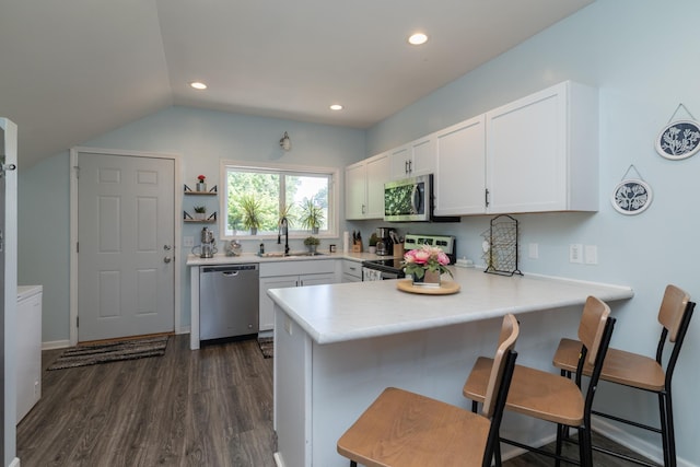 700 6th St E, Saint Paul, MN 55106 - kitchen with stainless steel appliances, a peninsula, dark wood-style floors, white cabinets, and light countertops
