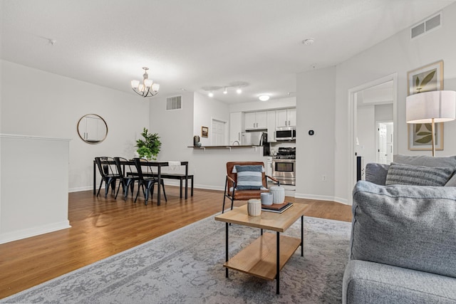 2566 Ellis Ave Unit 103, Saint Paul, MN 55114 - living area featuring a chandelier and wood finished floors