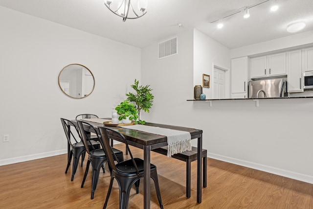 2566 Ellis Ave Unit 103, Saint Paul, MN 55114 - dining room with light wood finished floors and track lighting