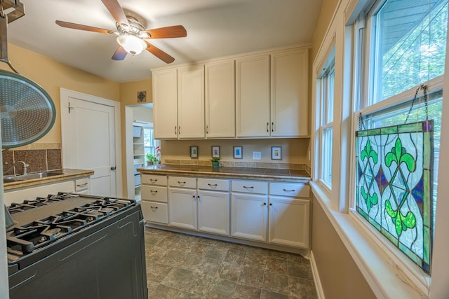 5229 42nd Ave S, Minneapolis, MN 55417 - kitchen featuring black gas range oven, white cabinetry, ceiling fan, and dark stone finish flooring