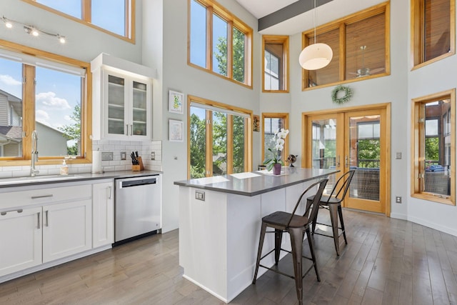 18675 86th Pl N, Maple Grove, MN 55311 - kitchen featuring dishwasher, a towering ceiling, a breakfast bar area, light wood-style floors, and white cabinets