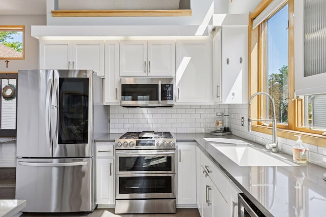 18675 86th Pl N, Maple Grove, MN 55311 - kitchen featuring stainless steel appliances, backsplash, white cabinetry, and light stone counters