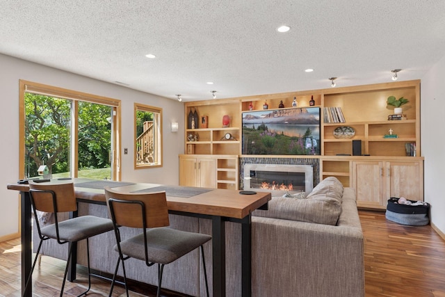 18675 86th Pl N, Maple Grove, MN 55311 - living room with a textured ceiling, wood finished floors, a glass covered fireplace, recessed lighting, and built in features