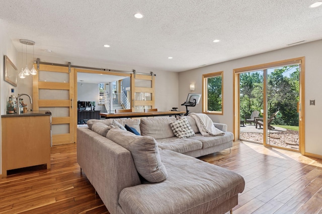 18675 86th Pl N, Maple Grove, MN 55311 - living area featuring a barn door, a textured ceiling, wood-type flooring, and recessed lighting
