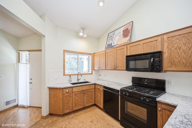 4224 93rd Ave N, Brooklyn Park, MN 55443 - kitchen with black appliances, backsplash, lofted ceiling, and light stone counters