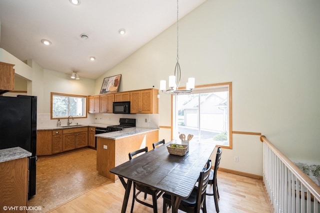4224 93rd Ave N, Brooklyn Park, MN 55443 - kitchen with black appliances, a chandelier, high vaulted ceiling, brown cabinetry, and a peninsula