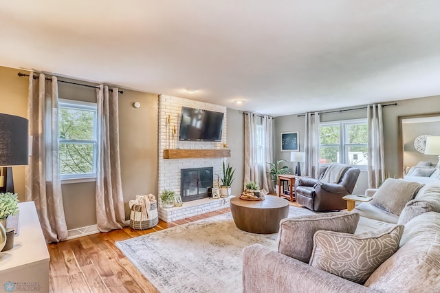 1800 Centre Sq, Moorhead, MN 56560 - living room featuring healthy amount of natural light, a brick fireplace, and light wood finished floors