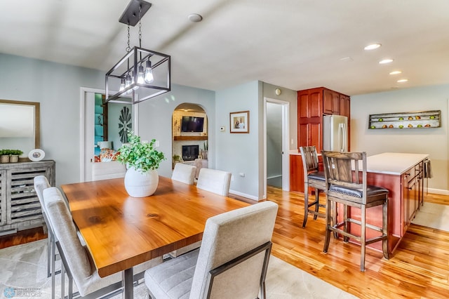 1800 Centre Sq, Moorhead, MN 56560 - dining room with light wood-type flooring, a fireplace, recessed lighting, a chandelier, and arched walkways