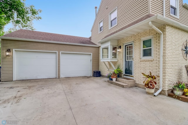 1800 Centre Sq, Moorhead, MN 56560 - entrance to property with concrete driveway, a garage, and roof with shingles