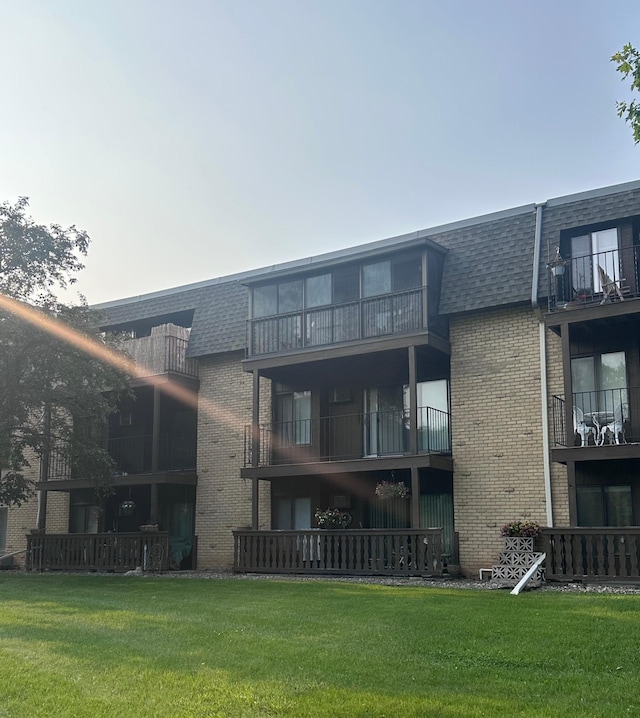 3421 Kent St Unit 607, Shoreview, MN 55126 - back of property with mansard roof, roof with shingles, brick siding, and a lawn