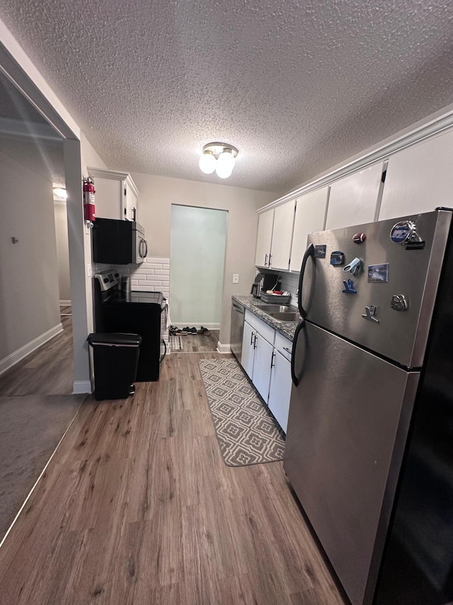 3421 Kent St Unit 607, Shoreview, MN 55126 - kitchen with stainless steel appliances, white cabinetry, wood finished floors, dark countertops, and a textured ceiling