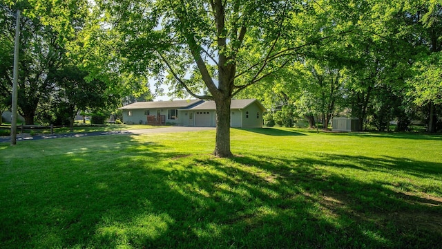 108 Viking Dr, Colfax, WI 54730 - view of green lawn with a storage shed, an attached garage, and driveway