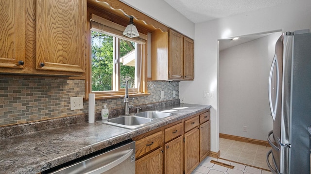 108 Viking Dr, Colfax, WI 54730 - kitchen with stainless steel appliances, decorative backsplash, brown cabinetry, and dark countertops