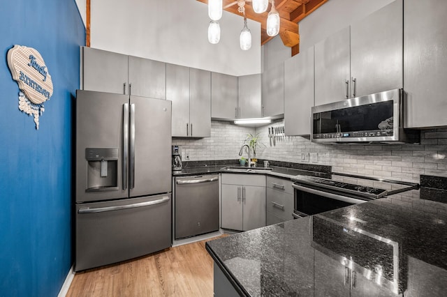 400 1st St Unit 611, Minneapolis, MN 55401 - kitchen with appliances with stainless steel finishes, dark stone countertops, backsplash, gray cabinets, and beamed ceiling