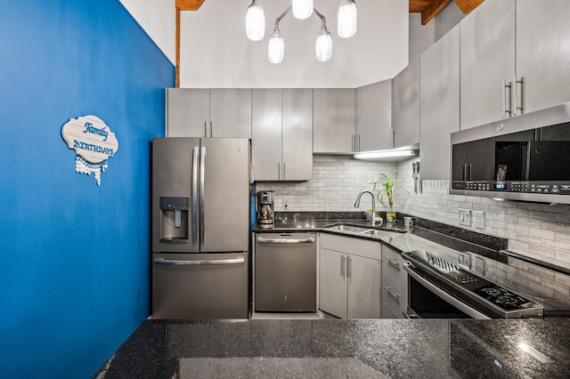 400 1st St Unit 611, Minneapolis, MN 55401 - kitchen featuring appliances with stainless steel finishes, backsplash, gray cabinetry, and dark stone counters