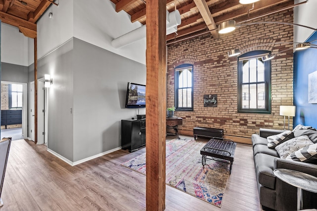 400 1st St Unit 611, Minneapolis, MN 55401 - living area with a wooden ceiling with exposed beams, brick wall, a high ceiling, wood finished floors, and healthy amount of natural light