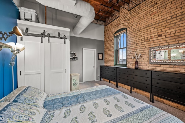 400 1st St Unit 611, Minneapolis, MN 55401 - bedroom with brick wall, a closet, a barn door, carpet flooring, and a high ceiling