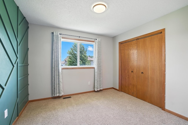 24155 Whispering Cir, East Bethel, MN 55005 - unfurnished bedroom with carpet floors, a closet, and a textured ceiling