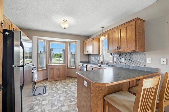 24155 Whispering Cir, East Bethel, MN 55005 - kitchen featuring stainless steel appliances, a peninsula, tasteful backsplash, a kitchen bar, and brown cabinetry