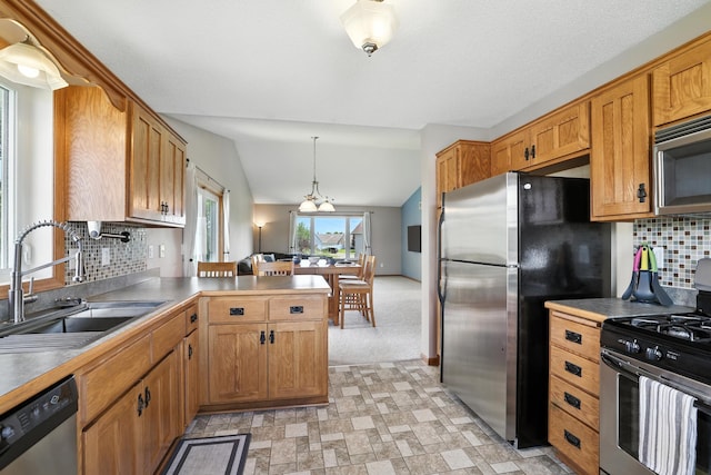 24155 Whispering Cir, East Bethel, MN 55005 - kitchen with appliances with stainless steel finishes, a peninsula, tasteful backsplash, lofted ceiling, and pendant lighting