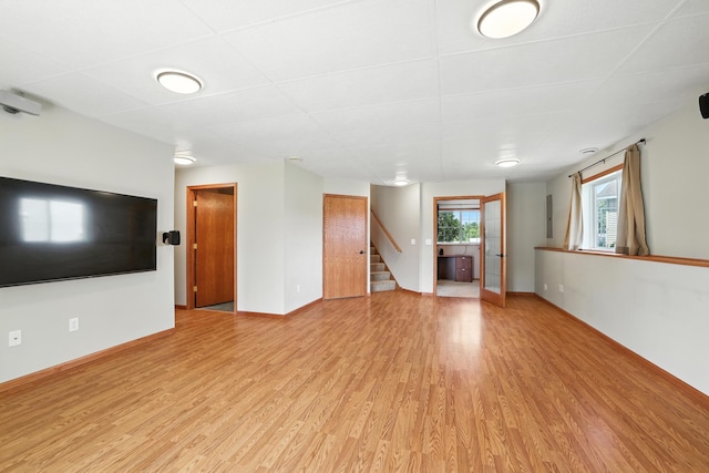 24155 Whispering Cir, East Bethel, MN 55005 - unfurnished living room featuring light wood-style flooring and stairs