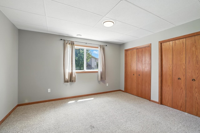 24155 Whispering Cir, East Bethel, MN 55005 - unfurnished bedroom featuring two closets, carpet, and a paneled ceiling