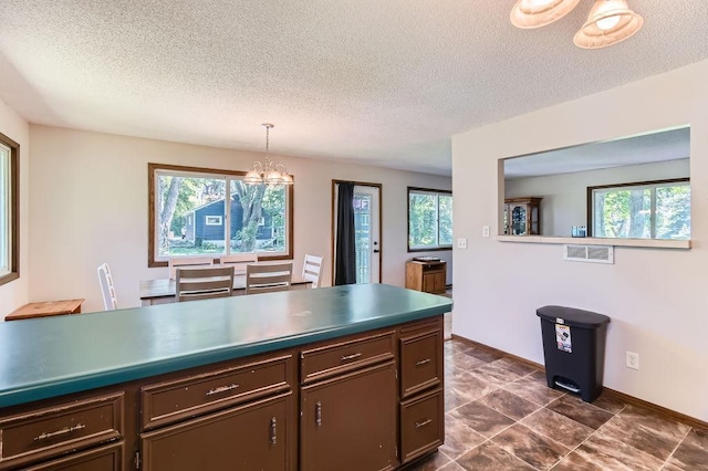14829 50th St N, Baytown Twp, MN 55082 - kitchen featuring a chandelier, healthy amount of natural light, a textured ceiling, and dark countertops