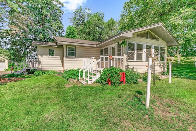 11965 State Highway 15, Kimball, MN 55353 - view of front of house featuring a sunroom, a front lawn, a shingled roof, and a wooden deck