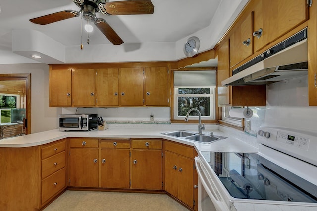 11965 State Highway 15, Kimball, MN 55353 - kitchen with white range with electric cooktop, under cabinet range hood, stainless steel microwave, brown cabinetry, and light countertops