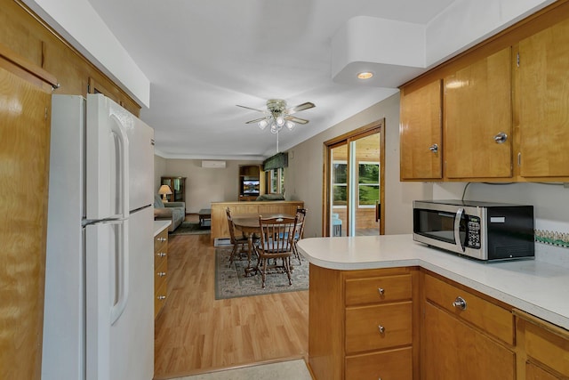 11965 State Highway 15, Kimball, MN 55353 - kitchen with stainless steel microwave, freestanding refrigerator, light countertops, a peninsula, and light wood finished floors